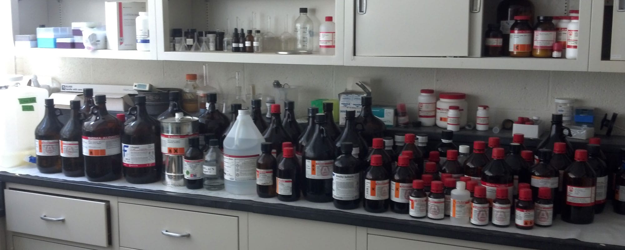 Laboratory reagent bottles lined on countertop