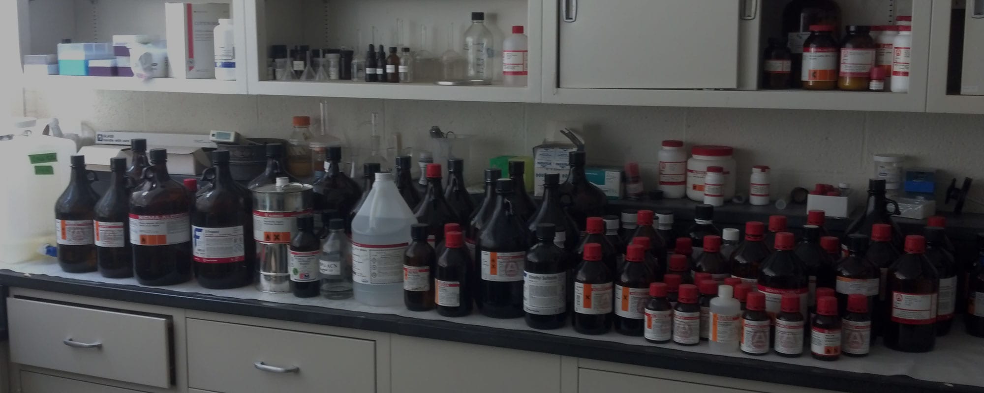lab reagent bottles on countertop